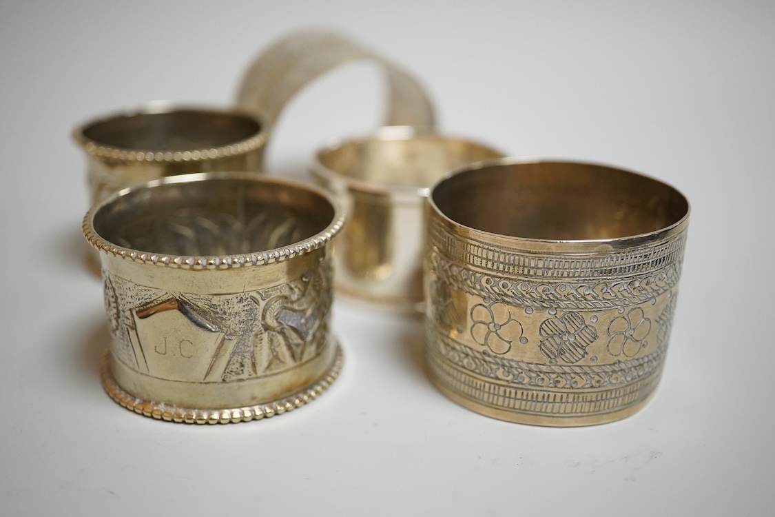 A modern silver mounted wine coaster, diameter 12cm, four silver napkin rings, four continental white metal napkin rings, a modern silver candle extinguisher, a silver tea strainer, small 925 shell dish, a George III sil